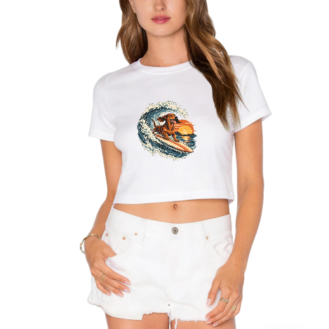 Surfing Dachshund Sunset Chase Women's Graphic Crop Tee featuring a surfing dachshund racing through a sunset wave